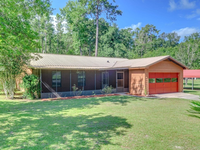 ranch-style house with driveway, a sunroom, metal roof, an attached garage, and a front yard