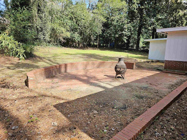 view of yard with a patio and an outdoor fire pit