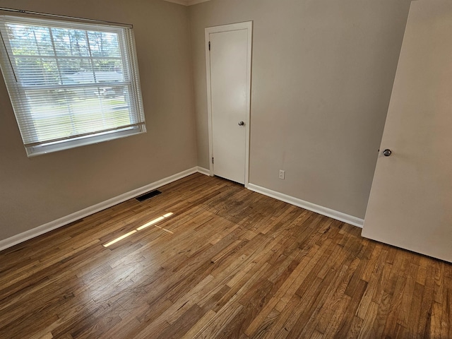 unfurnished bedroom with baseboards, visible vents, and hardwood / wood-style floors