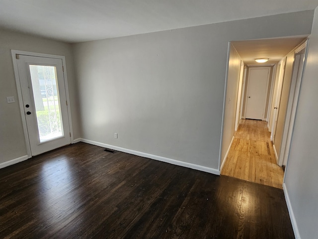 empty room featuring baseboards and wood finished floors