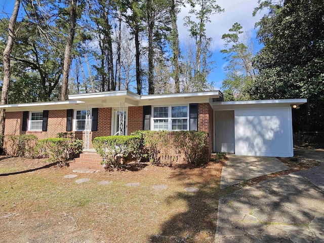 ranch-style home featuring an attached garage, driveway, and brick siding