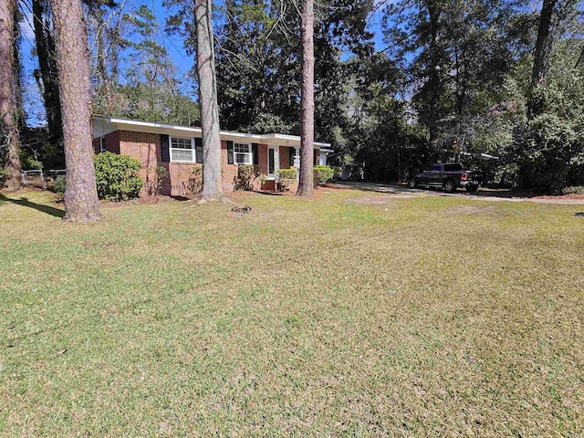 ranch-style home featuring brick siding and a front lawn