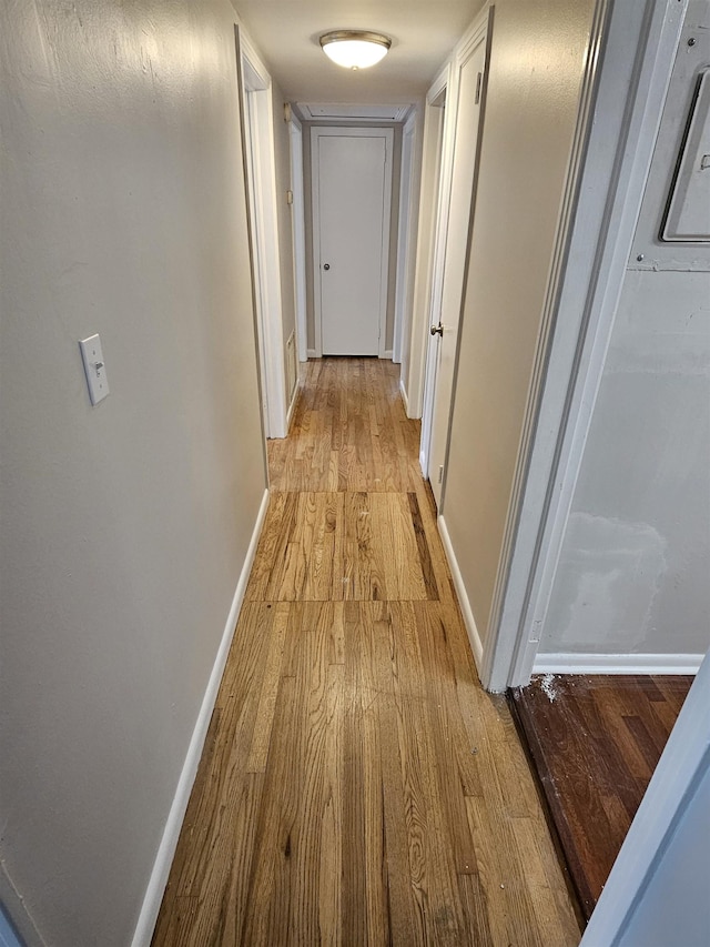 corridor featuring light wood-style floors and baseboards