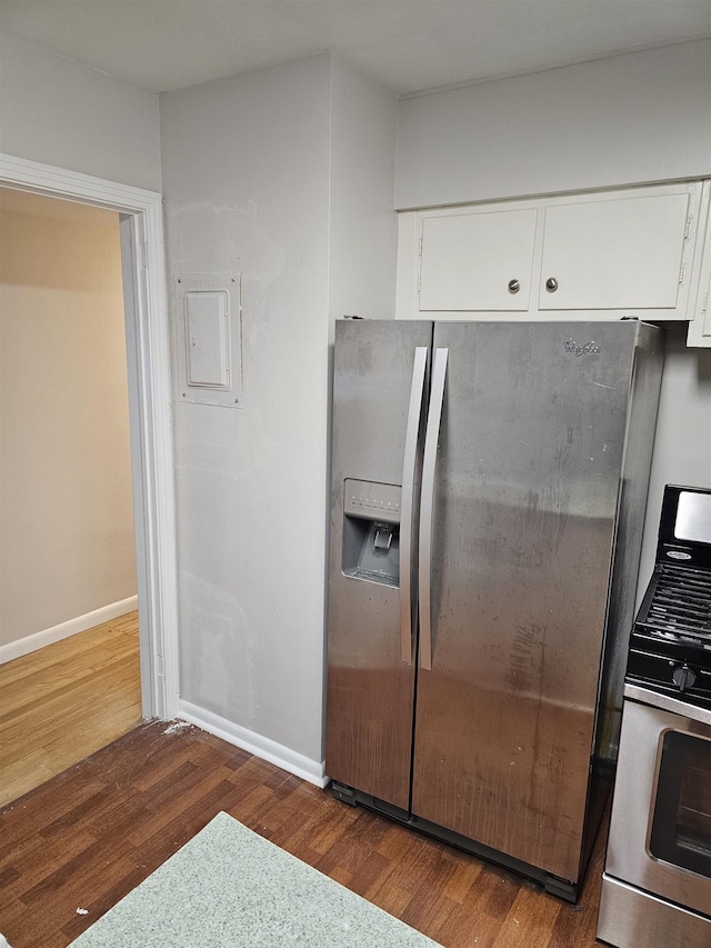 kitchen with white cabinets, baseboards, stainless steel appliances, and wood finished floors