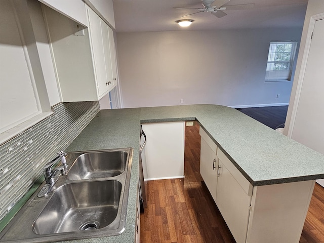 kitchen featuring tasteful backsplash, dark wood finished floors, ceiling fan, white cabinetry, and a sink