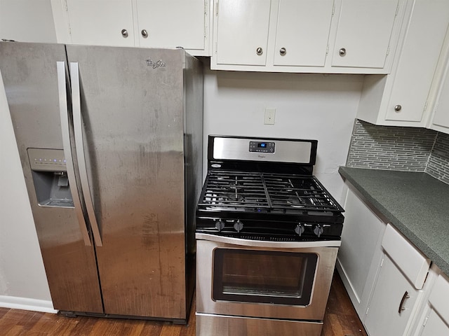 kitchen featuring tasteful backsplash, white cabinets, dark countertops, dark wood-style floors, and stainless steel appliances