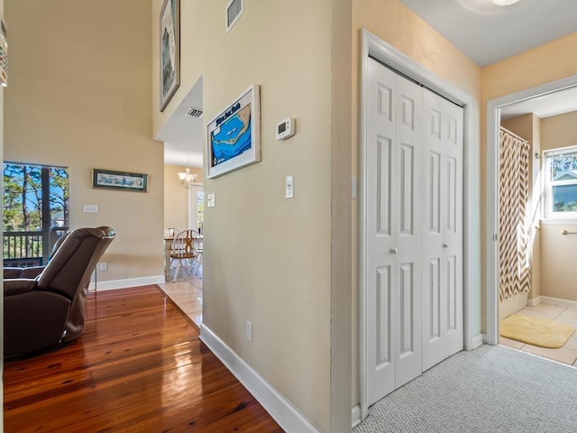 hall with hardwood / wood-style flooring and a notable chandelier