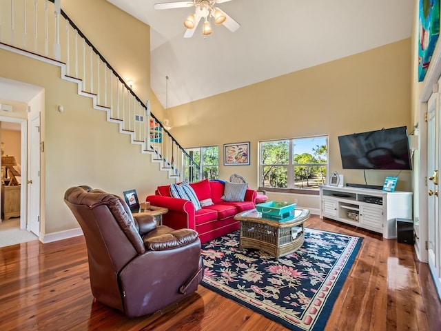 living room featuring hardwood / wood-style flooring, ceiling fan, and high vaulted ceiling