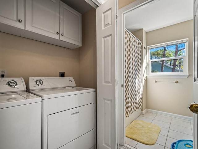 washroom with cabinets, light tile patterned floors, and washer and dryer