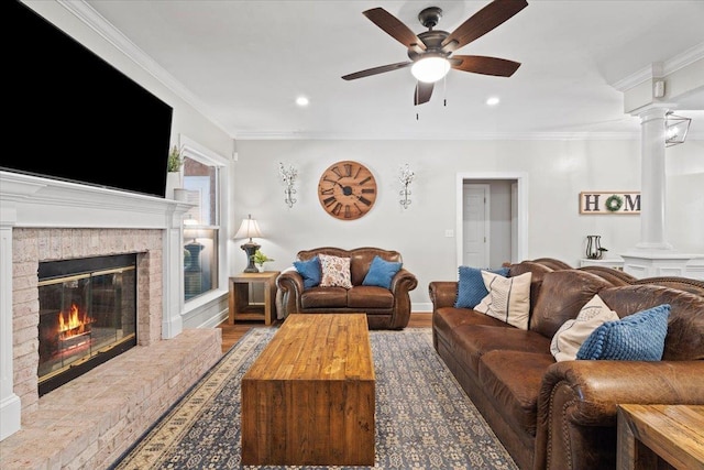9816 Thunder Hill Trl, Tallahassee, FL 32312 - living area featuring decorative columns, a ceiling fan, a brick fireplace, ornamental molding, and wood finished floors