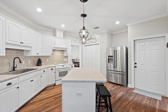 9816 Thunder Hill Trl, Tallahassee, FL 32312 - kitchen with high end refrigerator, white range with electric cooktop, dark wood-style floors, a center island, and ornamental molding