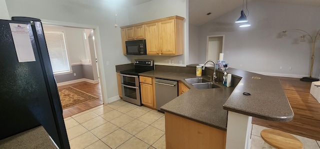 kitchen with light hardwood / wood-style floors, lofted ceiling, kitchen peninsula, black appliances, and sink