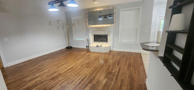 unfurnished living room featuring hardwood / wood-style flooring and a large fireplace