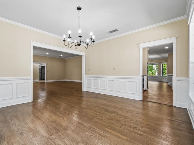 unfurnished dining area featuring ornamental molding, an inviting chandelier, and dark hardwood / wood-style floors