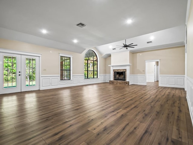 unfurnished living room with lofted ceiling, a healthy amount of sunlight, and dark hardwood / wood-style flooring