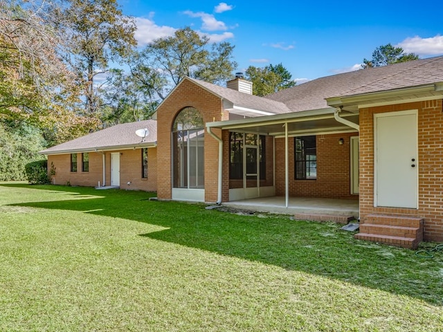 rear view of property featuring a yard and a patio area