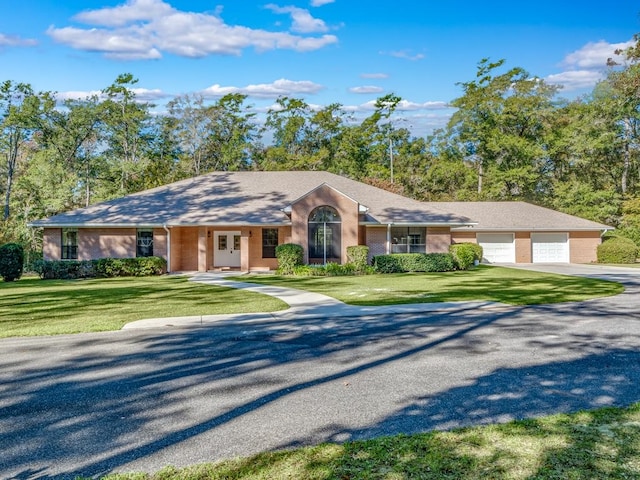 single story home with a garage and a front lawn