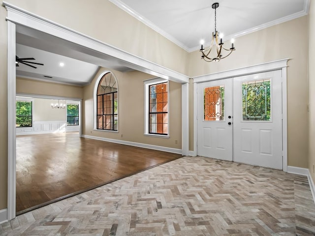 foyer entrance featuring light parquet flooring, ceiling fan with notable chandelier, and crown molding