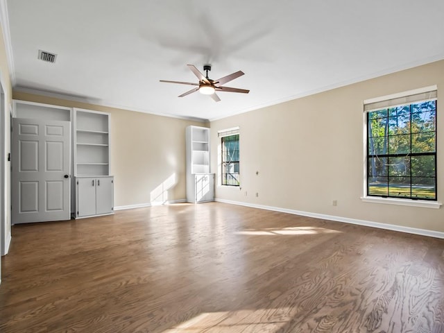 spare room with hardwood / wood-style floors, a wealth of natural light, and ornamental molding