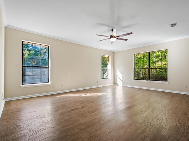 empty room with hardwood / wood-style flooring, a healthy amount of sunlight, and ornamental molding