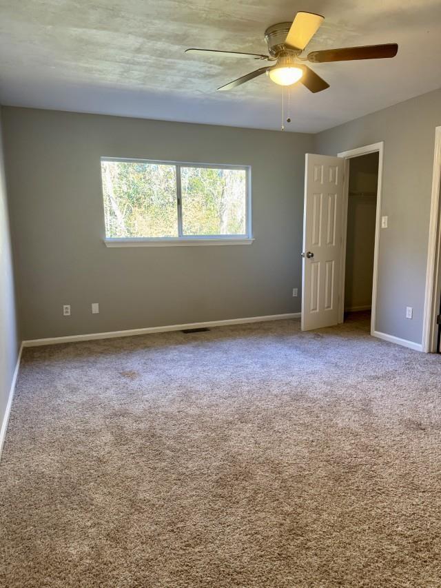 spare room featuring carpet flooring and ceiling fan