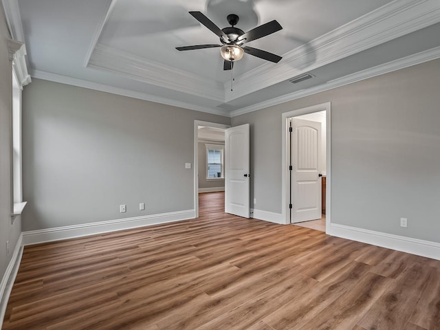 27 Spokan Trl, Crawfordville, FL 32327 - unfurnished bedroom featuring light wood-style flooring, crown molding, a raised ceiling, and ceiling fan