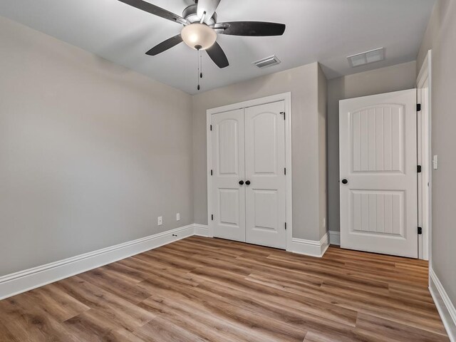 27 Spokan Trl, Crawfordville, FL 32327 - unfurnished bedroom with light wood finished floors, a closet, and a ceiling fan