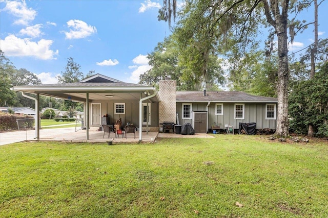 rear view of house featuring a patio and a lawn