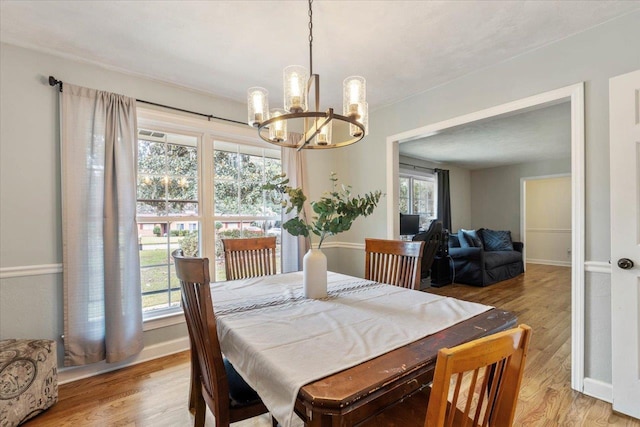 dining room featuring a notable chandelier and light wood-type flooring