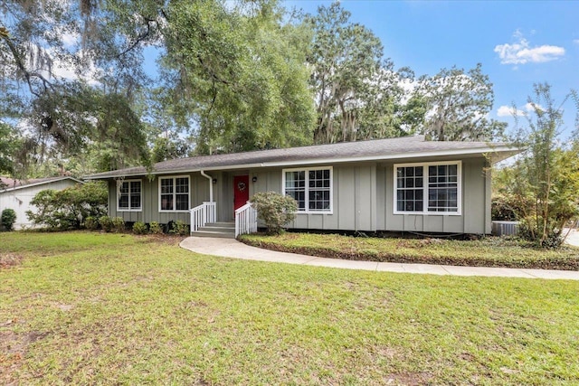 ranch-style home with a front yard and central air condition unit