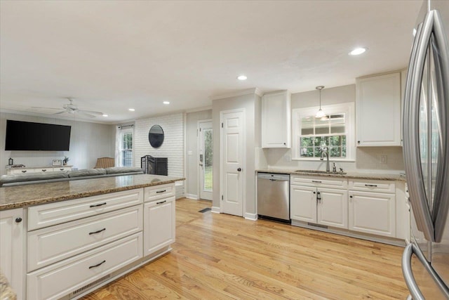 kitchen with white cabinetry, sink, pendant lighting, and stainless steel appliances