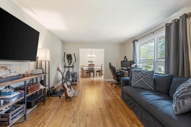 living room featuring a notable chandelier and light wood-type flooring