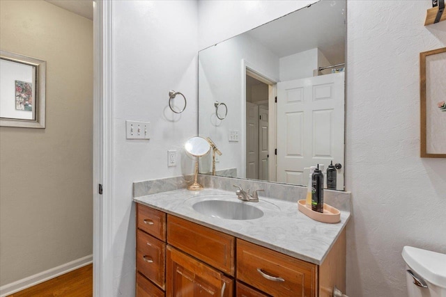 bathroom featuring vanity, hardwood / wood-style floors, and toilet