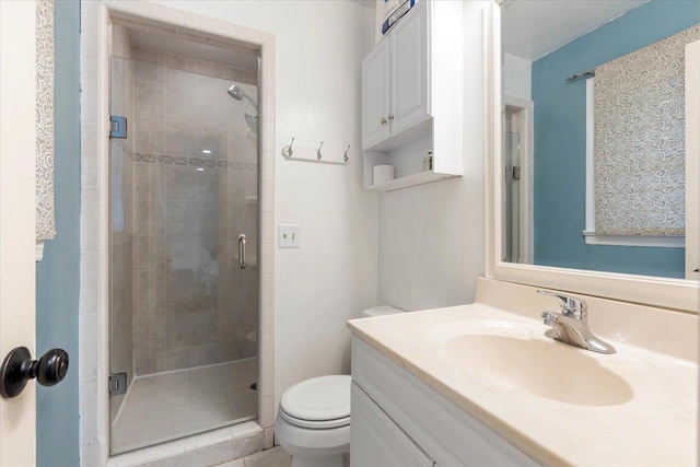 bathroom featuring vanity, an enclosed shower, and toilet