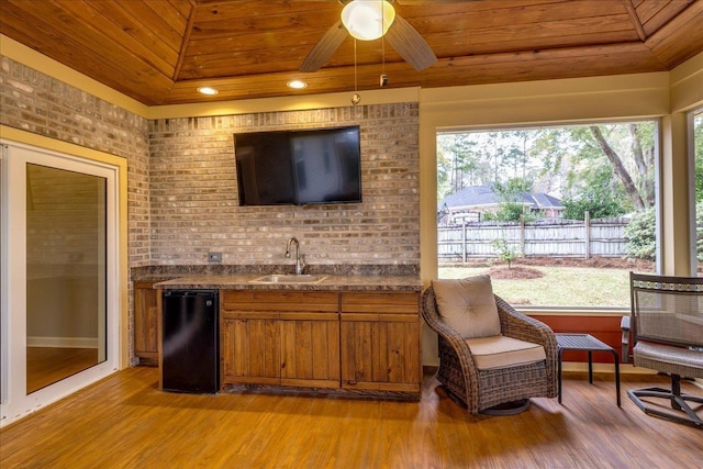 bar featuring plenty of natural light, fridge, a sink, and wooden ceiling