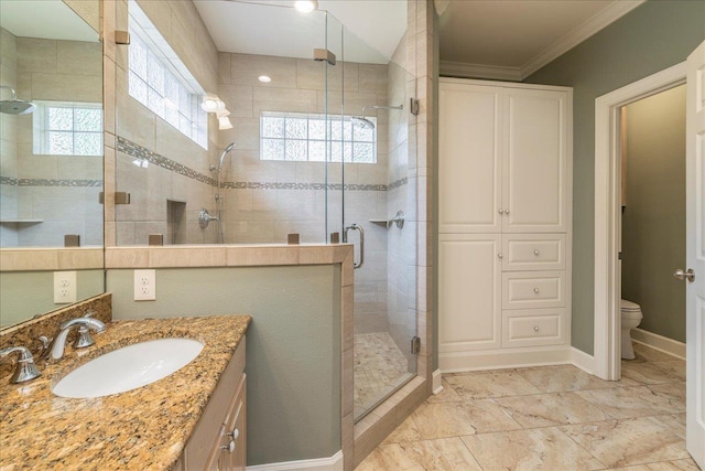 bathroom featuring toilet, vanity, baseboards, a stall shower, and crown molding