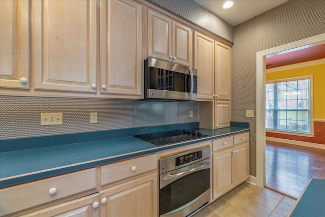 kitchen featuring dark countertops, stainless steel appliances, and light brown cabinetry