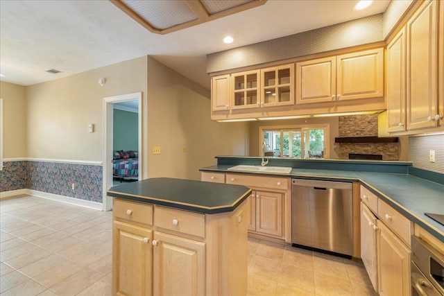 kitchen with appliances with stainless steel finishes, dark countertops, light brown cabinets, and a sink