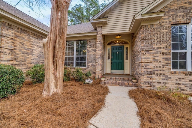 view of exterior entry featuring brick siding