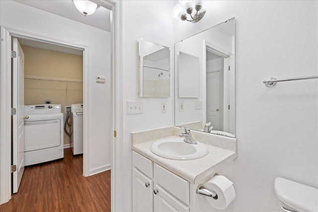 bathroom featuring hardwood / wood-style floors, washer and dryer, vanity, and toilet