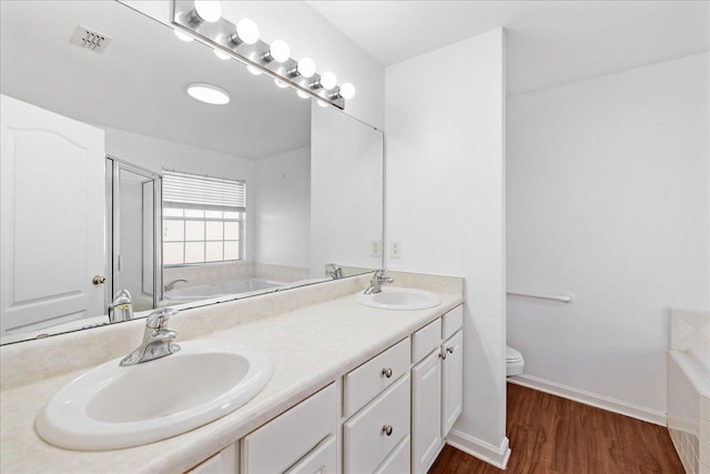 bathroom featuring hardwood / wood-style floors, a bath, toilet, and vanity