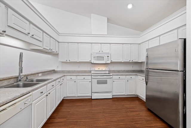 kitchen featuring white appliances, white cabinetry, sink, and vaulted ceiling