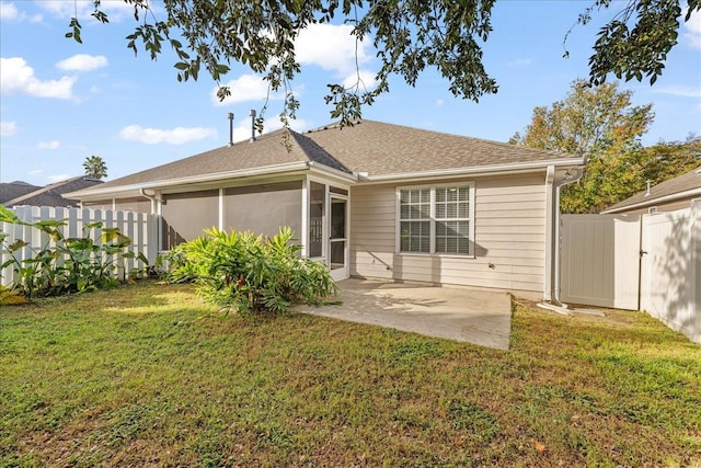 rear view of property featuring a yard and a patio area