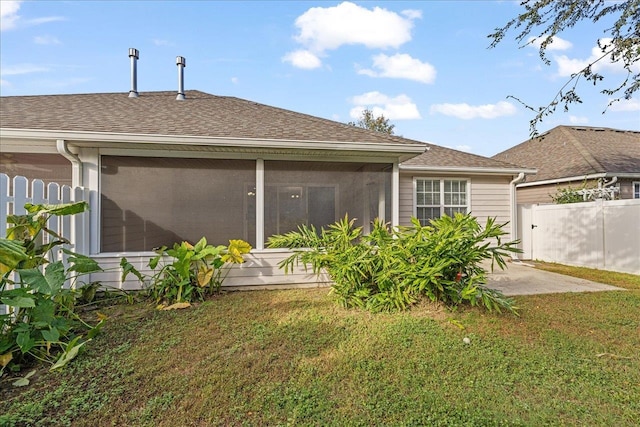 rear view of house featuring a patio, a sunroom, and a yard