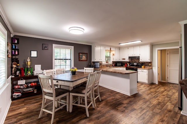 dining area featuring crown molding and dark wood-style flooring