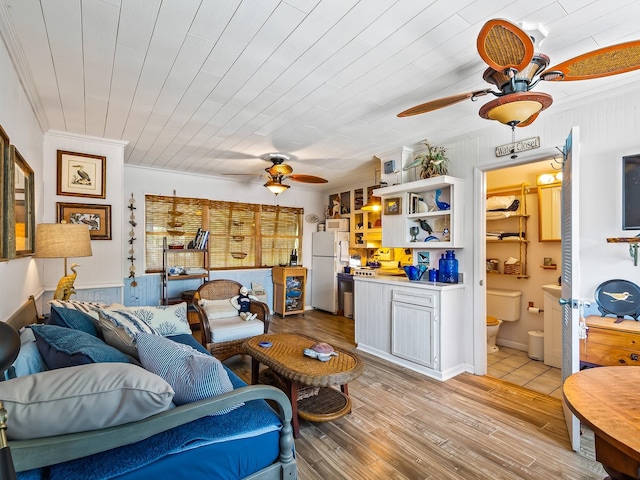 living room with ornamental molding, ceiling fan, and light hardwood / wood-style flooring