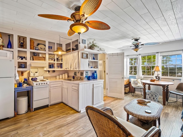 kitchen with light wood-type flooring, white appliances, and hanging light fixtures