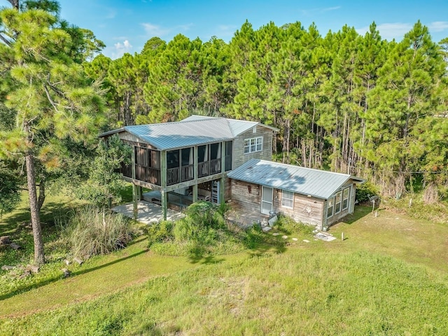 back of property with a sunroom and a yard