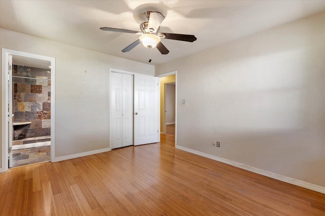 unfurnished bedroom with a closet, ensuite bathroom, ceiling fan, and light hardwood / wood-style floors