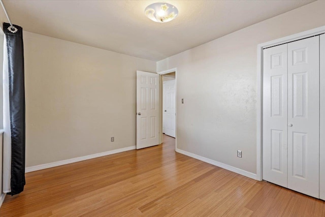 unfurnished bedroom with a closet and light hardwood / wood-style floors